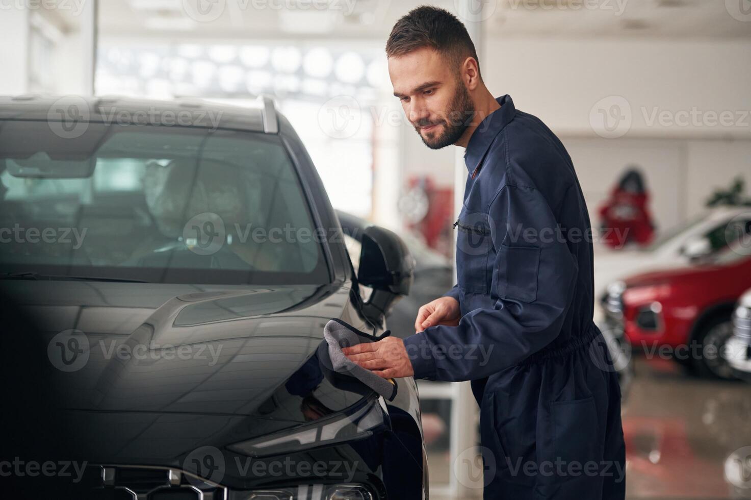 Polishing the vehicle. Car ,repairman is in the garage with automobile photo