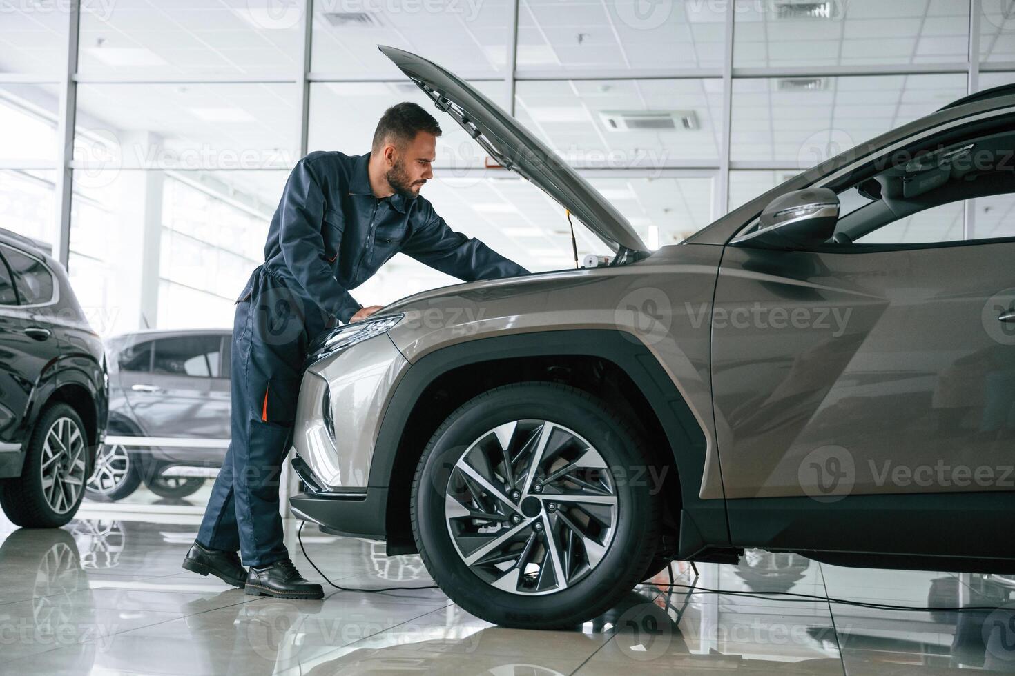 Fixing the, vehicle,. Side view. Car repairman is in the garage with automobile photo