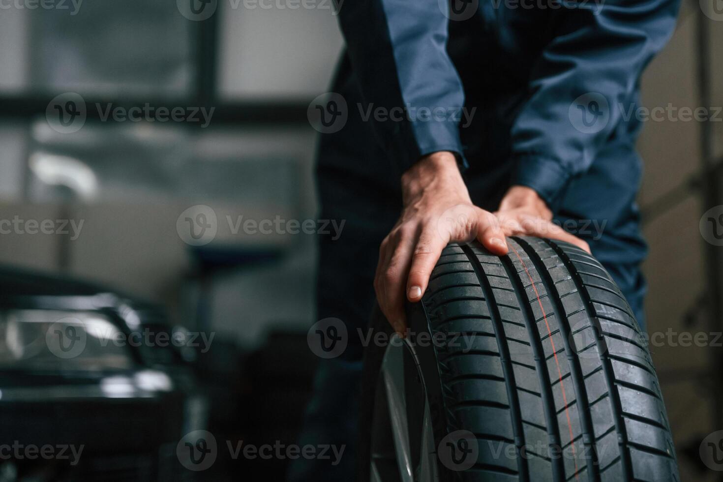 Close up view of man that is moving tire of the car photo