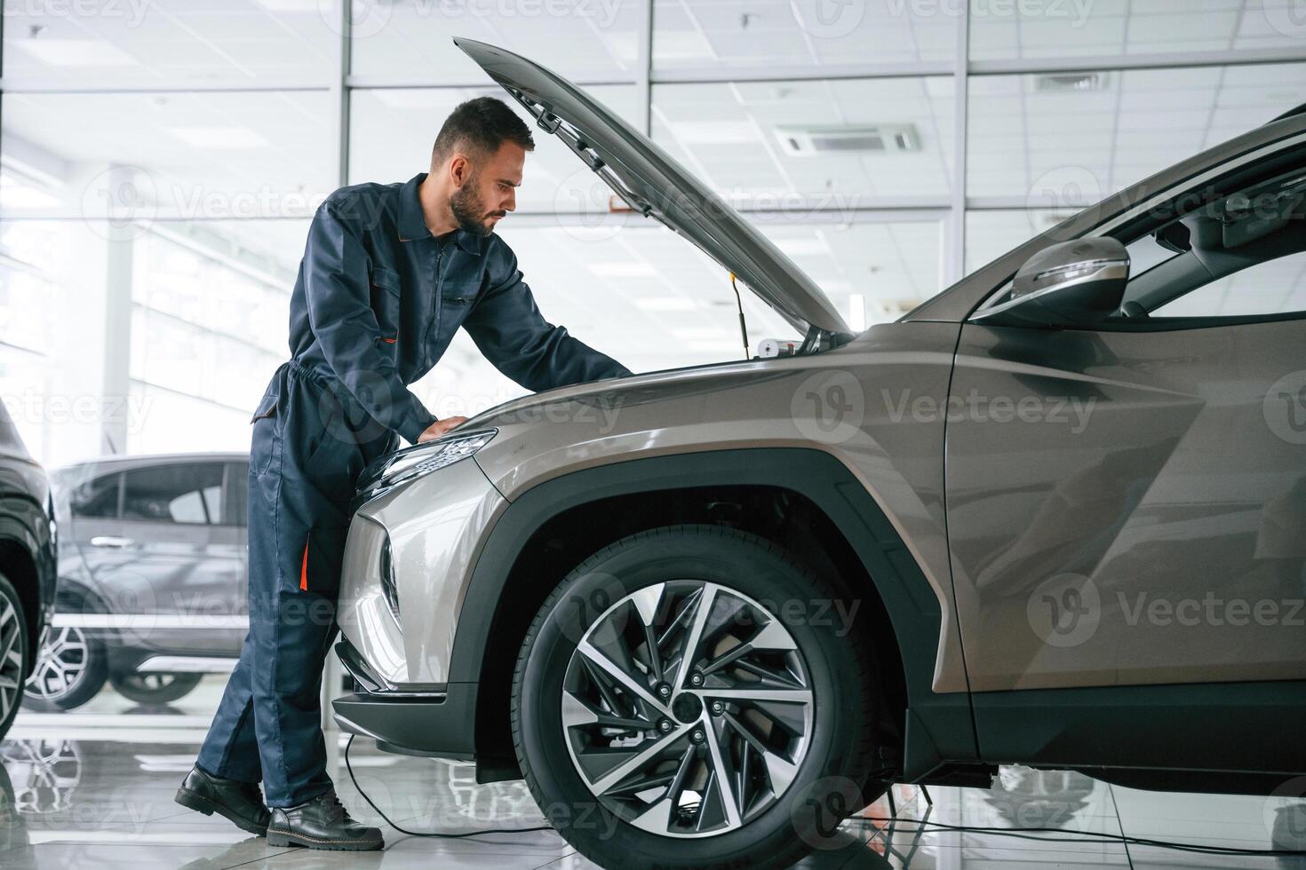 Fixing, the ,vehicle. Side view. Car repairman is in the garage with automobile photo