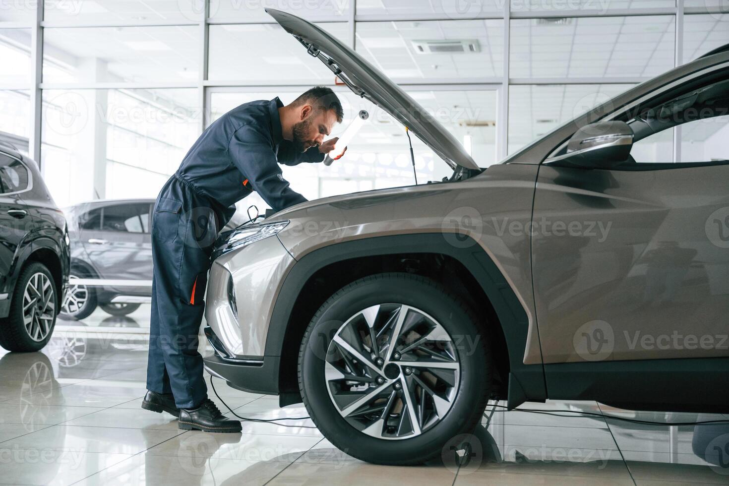 View ,from, the side. Car repairman is in the garage with automobile photo