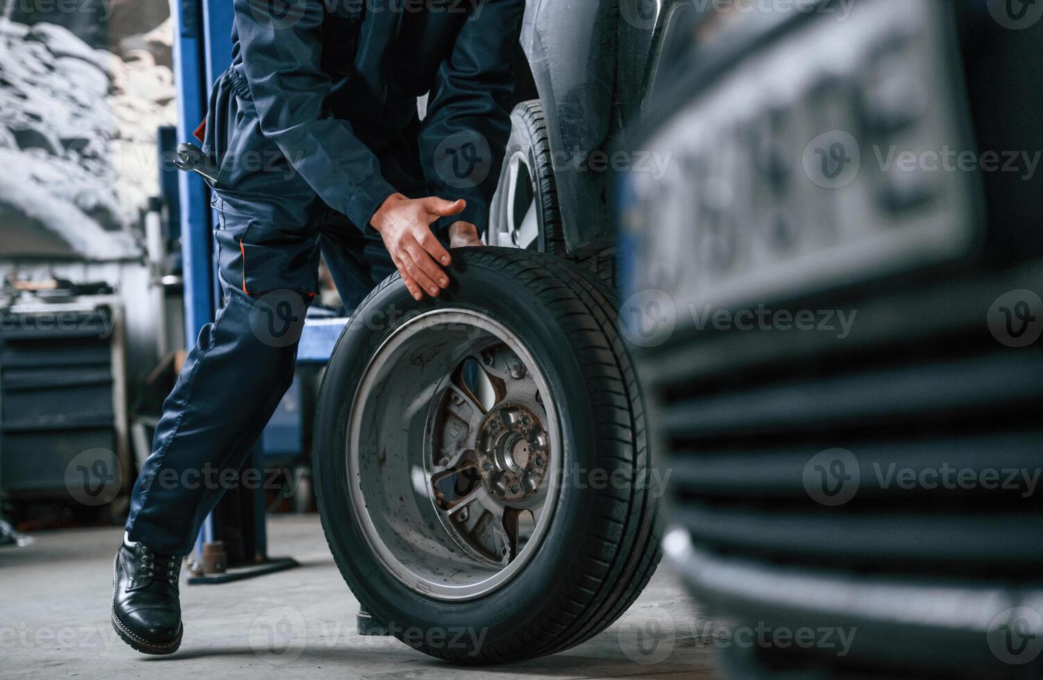 Close, up view, of man that is moving tire of the car photo