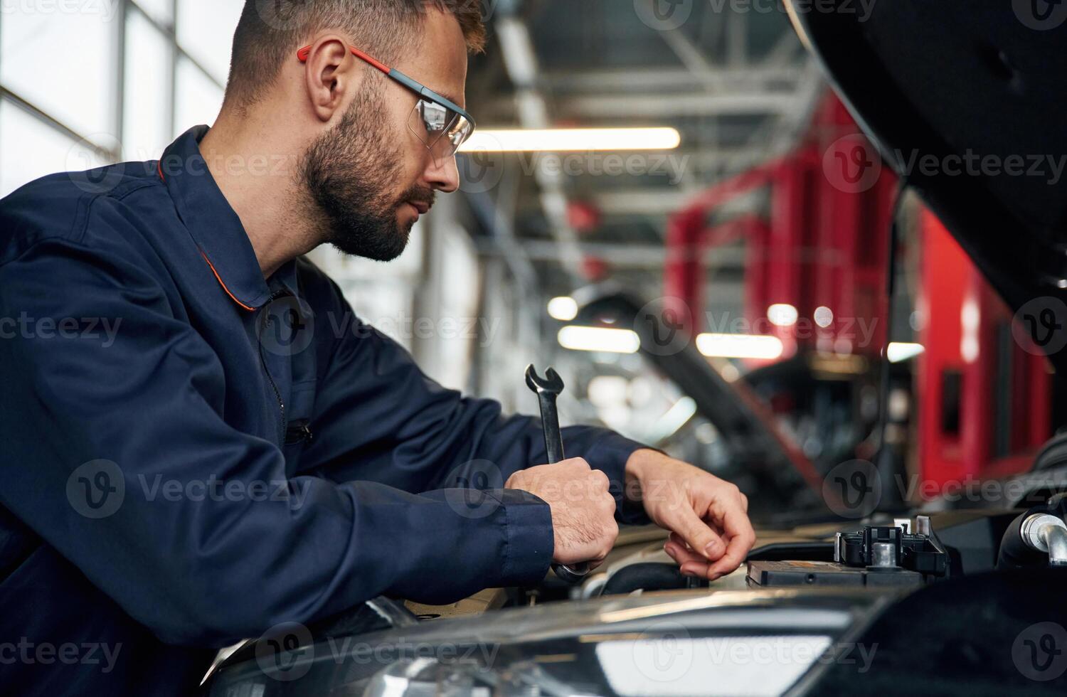 Hood, is ,opened, fixing. Car repairman is in the garage with automobile photo