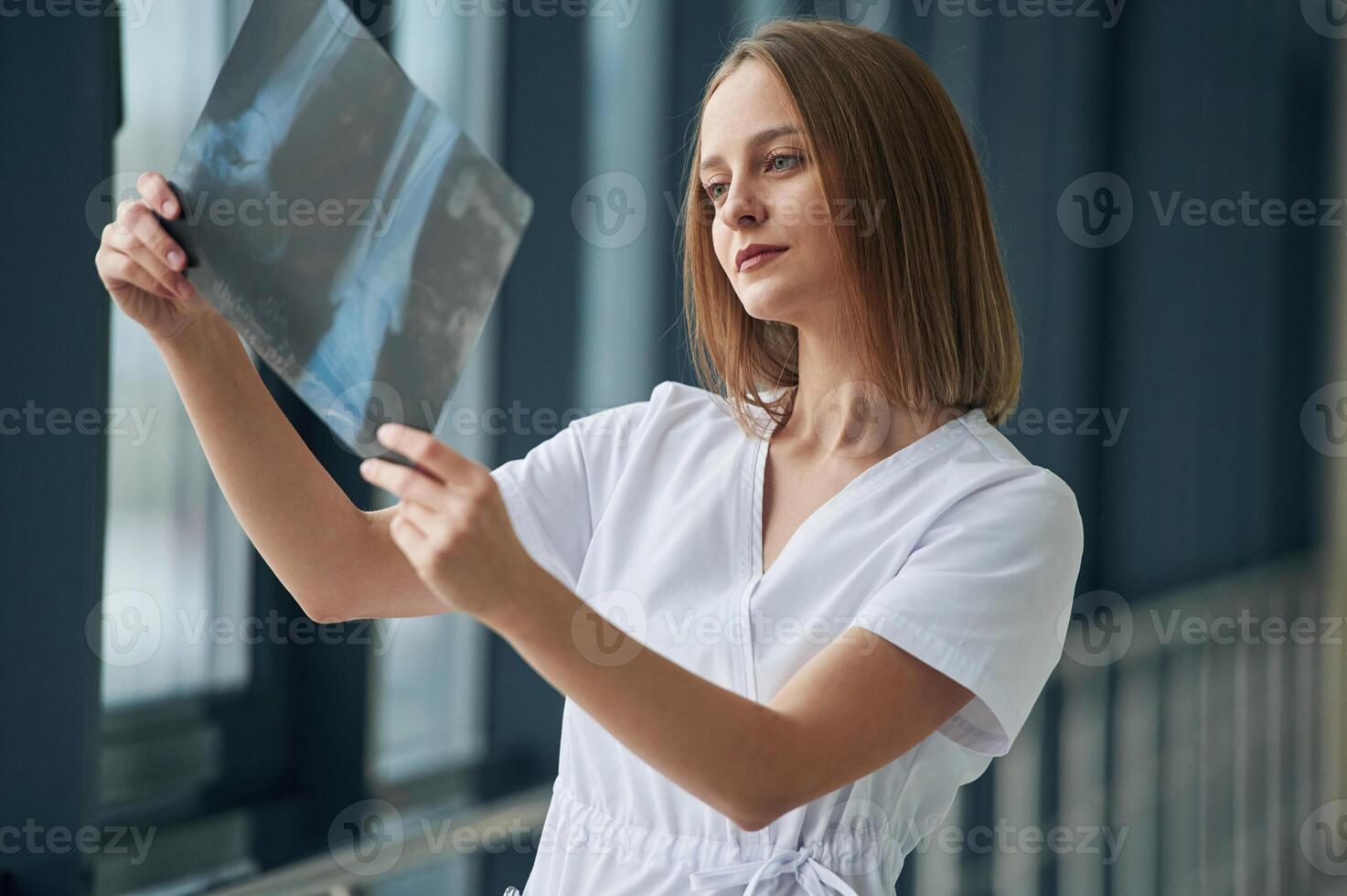 Examining x-ray. Female doctor in white ,,coat is in the hall photo