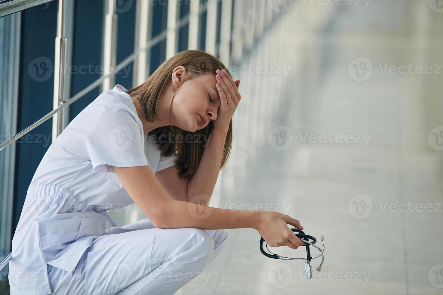 Tired, feeling bad, exhausted.. Female ,doctor in white coat is in the hall photo