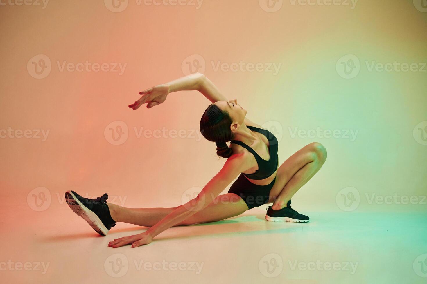 Hands and legs exercise. Young ,fitness woman in sportive clothes against background in studio photo
