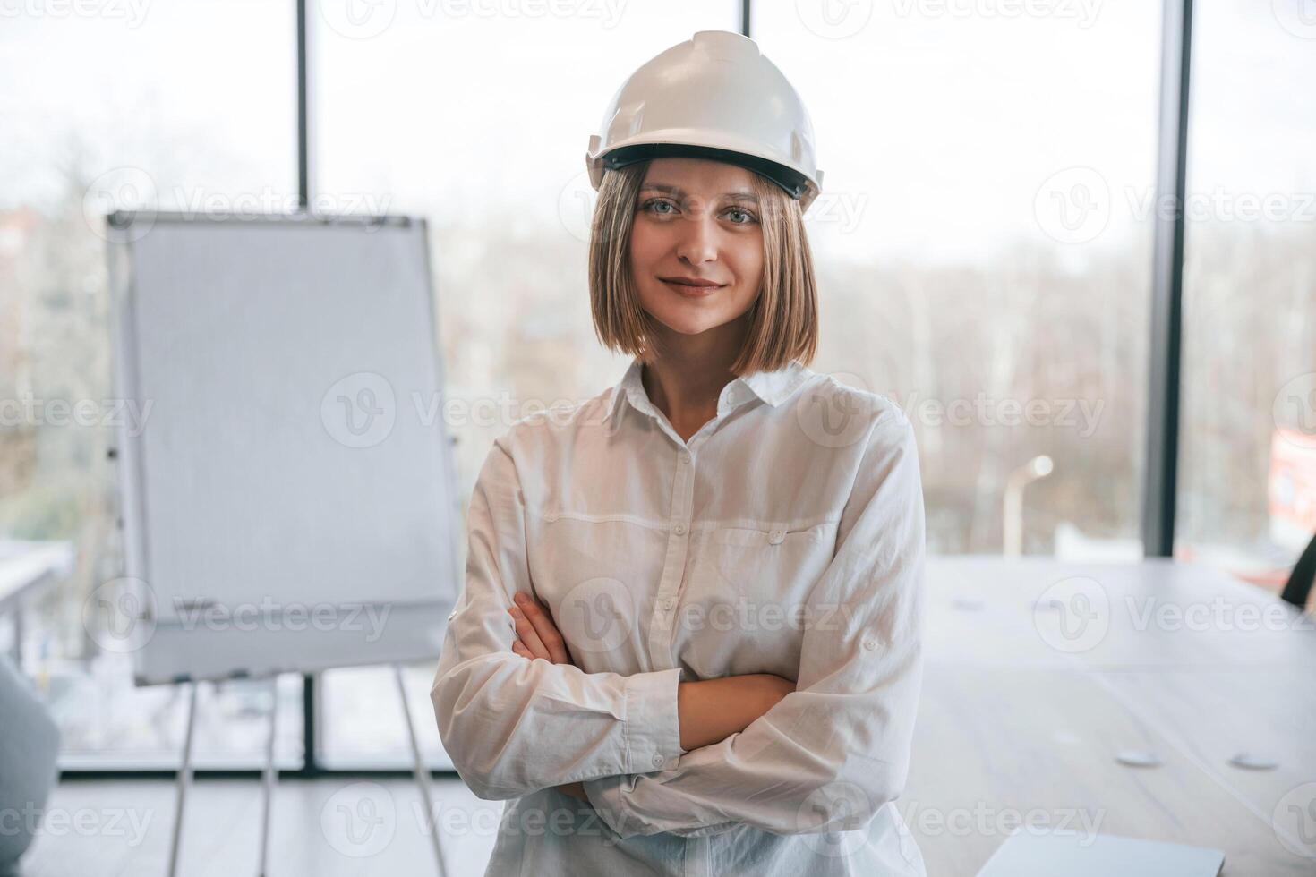 Young woman, architect in hard hat is in office photo
