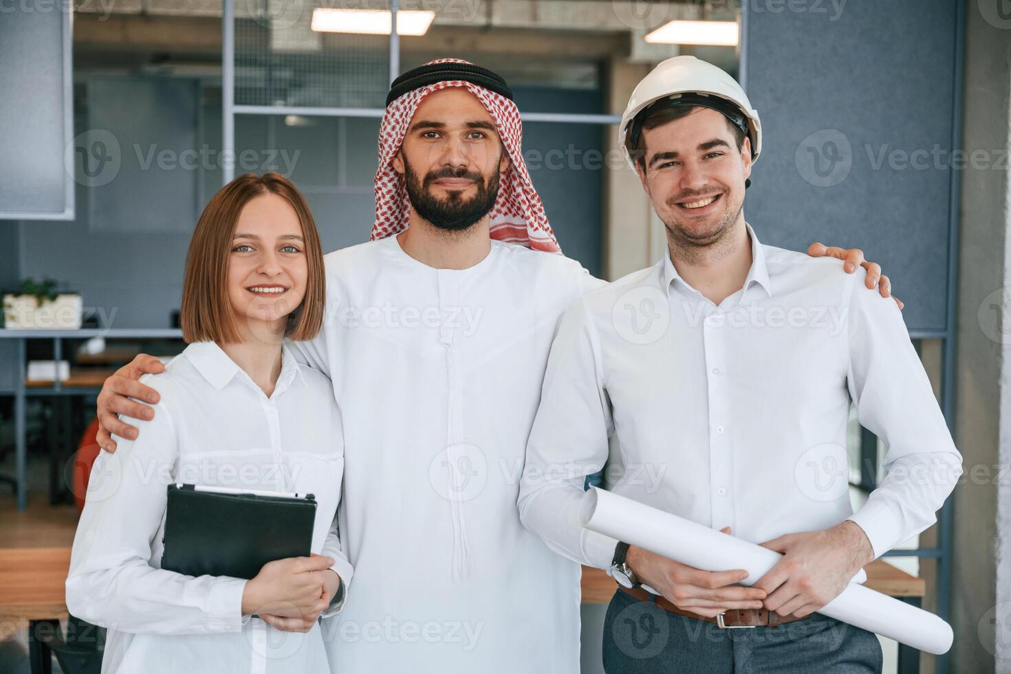 Standing together., Muslim businessman in traditional outfit with colleagues in office photo