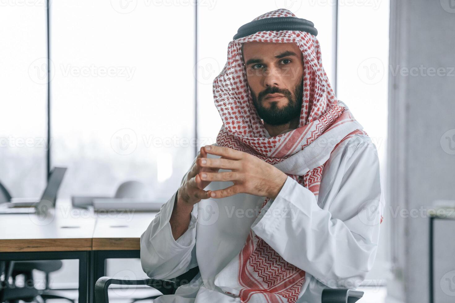 Normal ,work day. Successful Muslim businessman in traditional outfit in his office photo