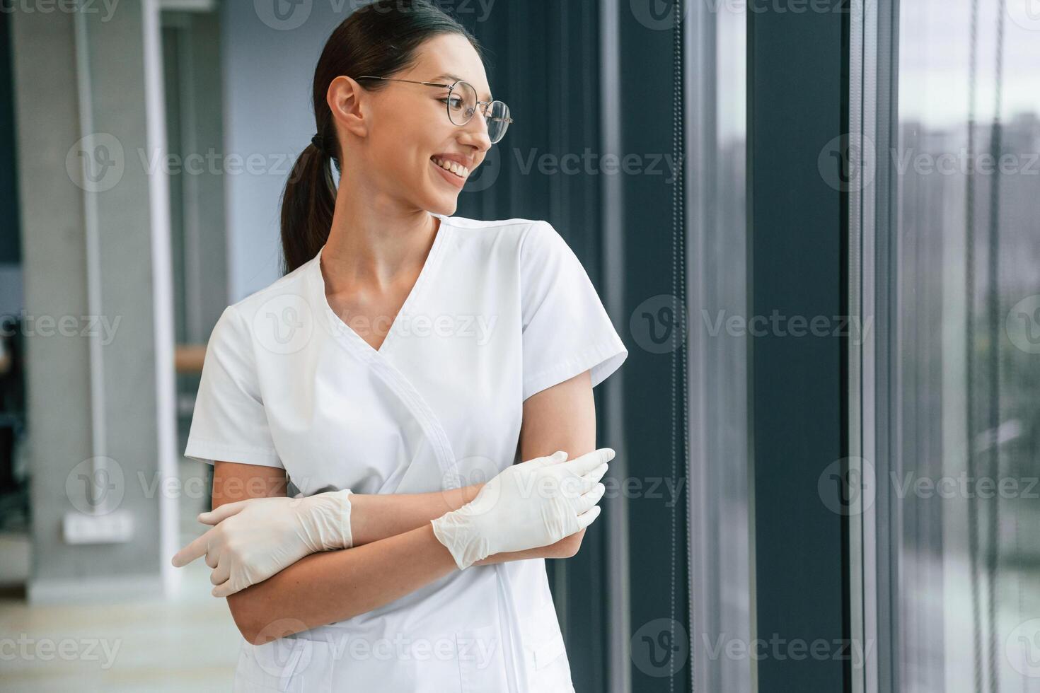 Cheerful ,,female doctor in white coat is indoors standing and smiling photo