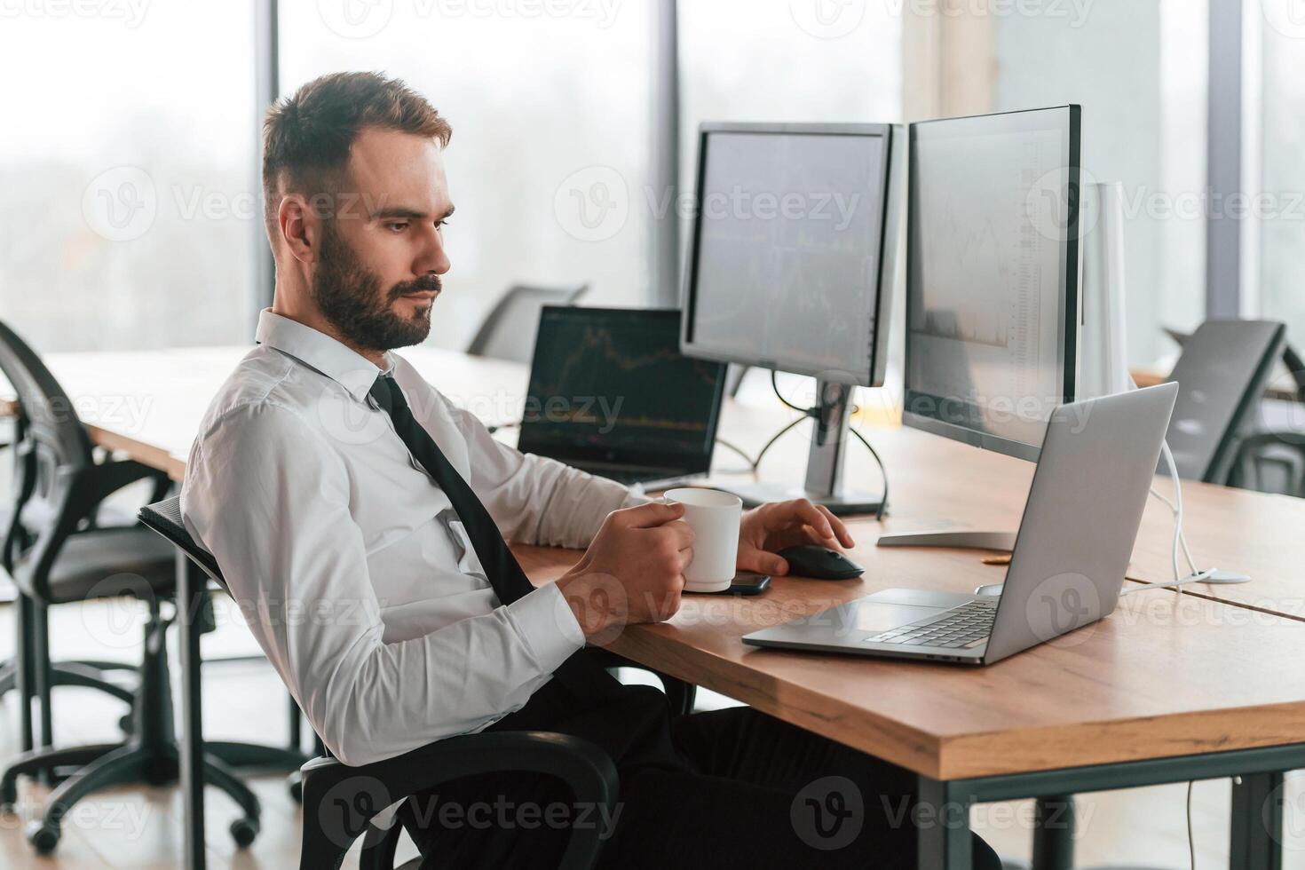 Using laptop.. Businessman is sitting by computer and working in the office photo
