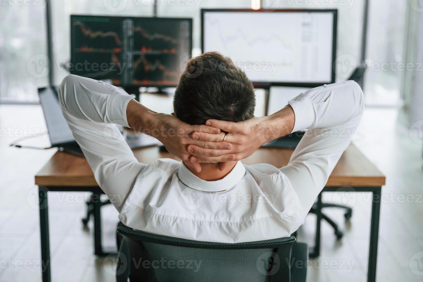 Rear view.. Businessman is sitting by computer and working in the office photo