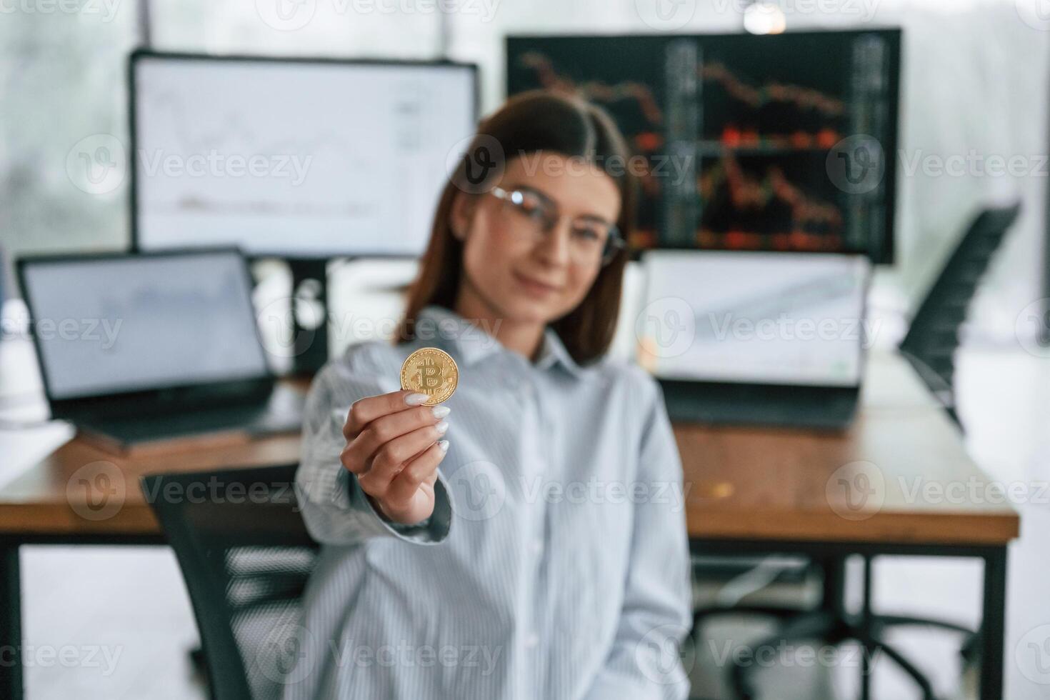 Digital, currency, conception of stock. Golden coin in hand. Businesswoman is working in the office photo