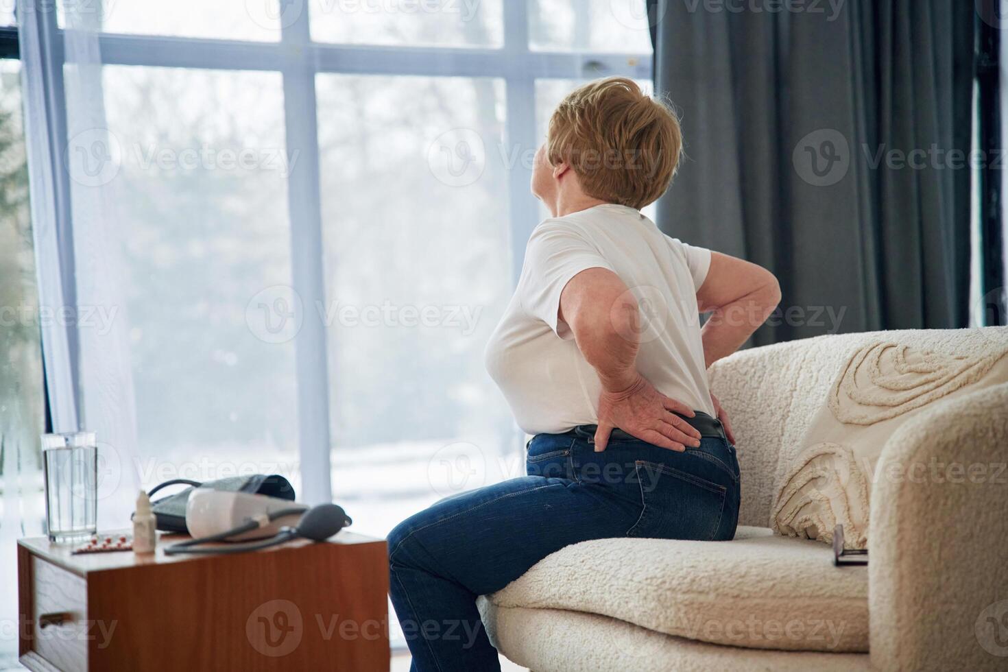 Back pain. Senior elderly woman is at home in, the, living room photo