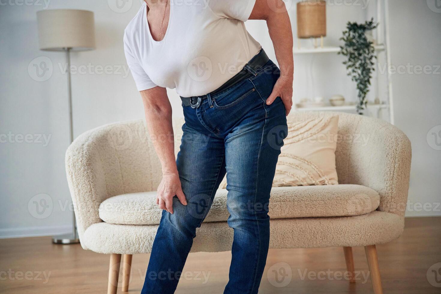 Pain in the leg. Senior, elderly woman is at home in the living room photo
