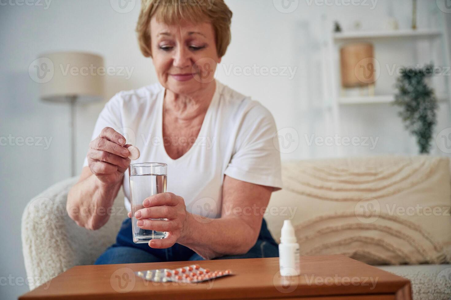 Taking the ,medicine, conception of illness. Senior elderly woman is at home in the living room photo