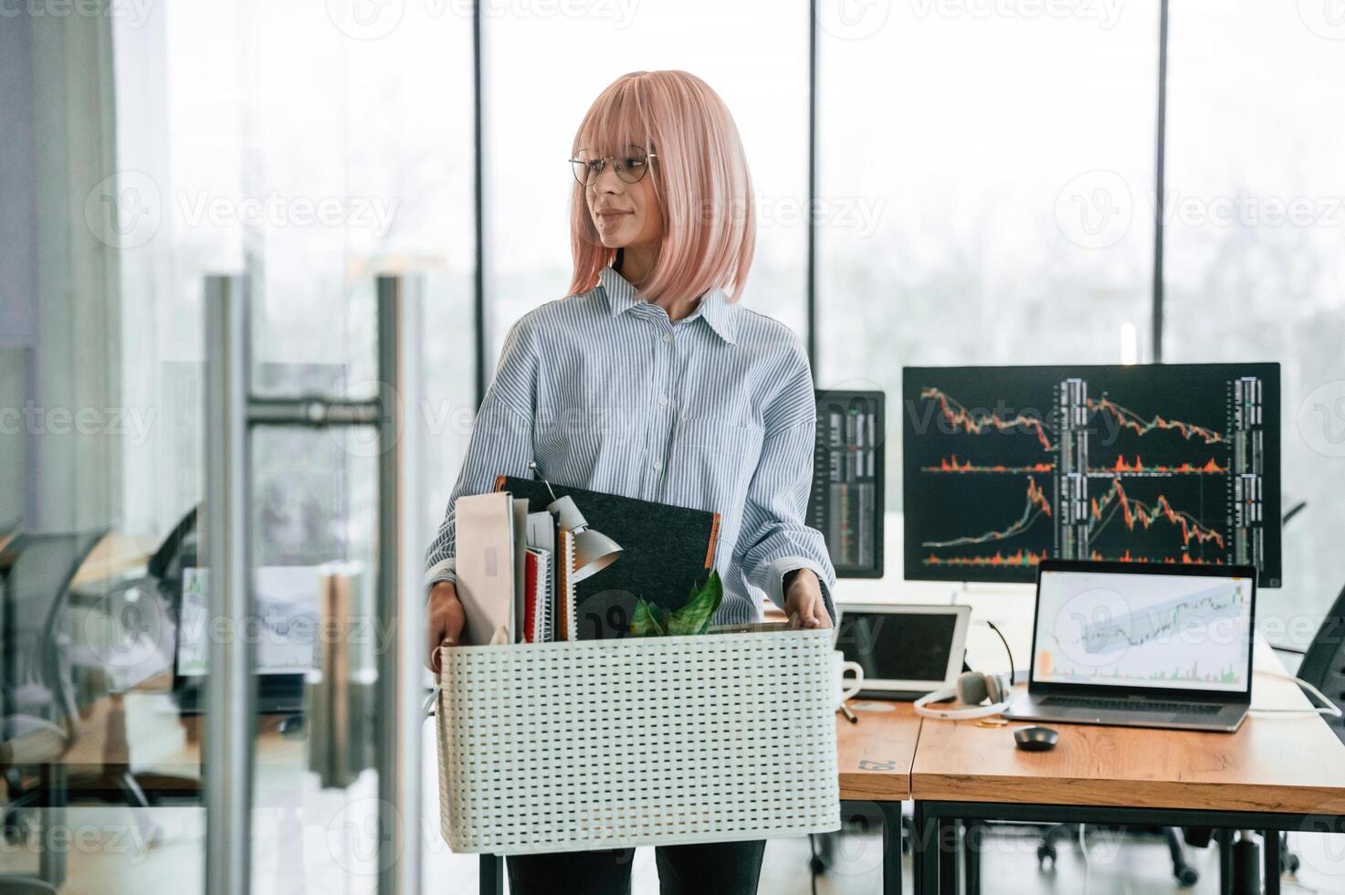 Unemployed woman with pink hair ,is ,,with personal belongings after being fired photo