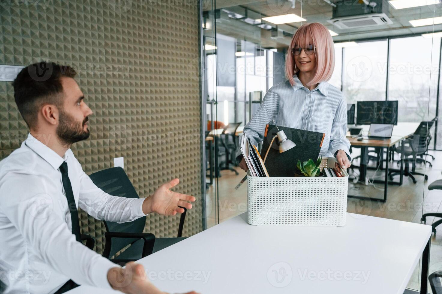 Woman is giving the man box with his belongings, guy getting fired photo