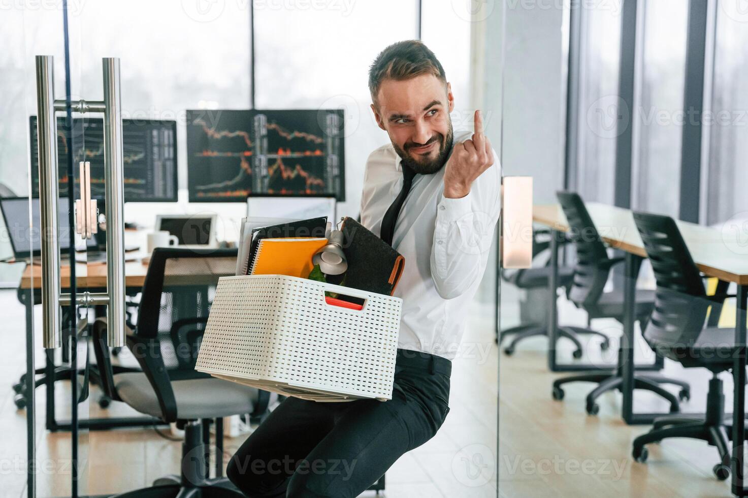 Showing, middle ,finger. Unemployed, man is with personal belongings after being fired photo