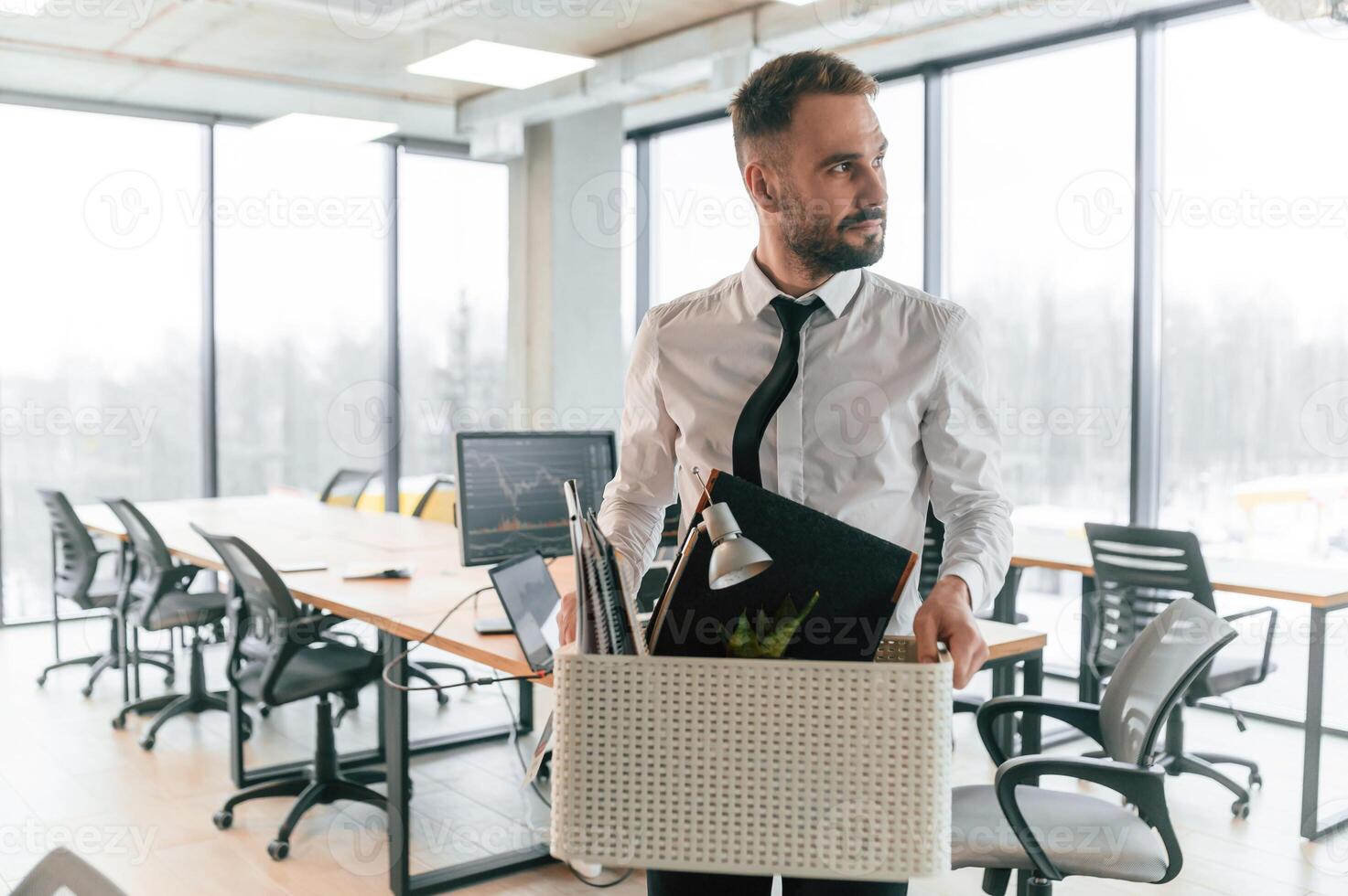 With box in, hands. Unemployed man is with personal belongings after being fired photo