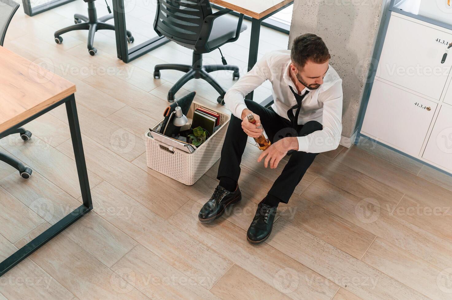 Feeling,, bad, sitting, on floor. Unemployed man is with personal belongings after being fired photo