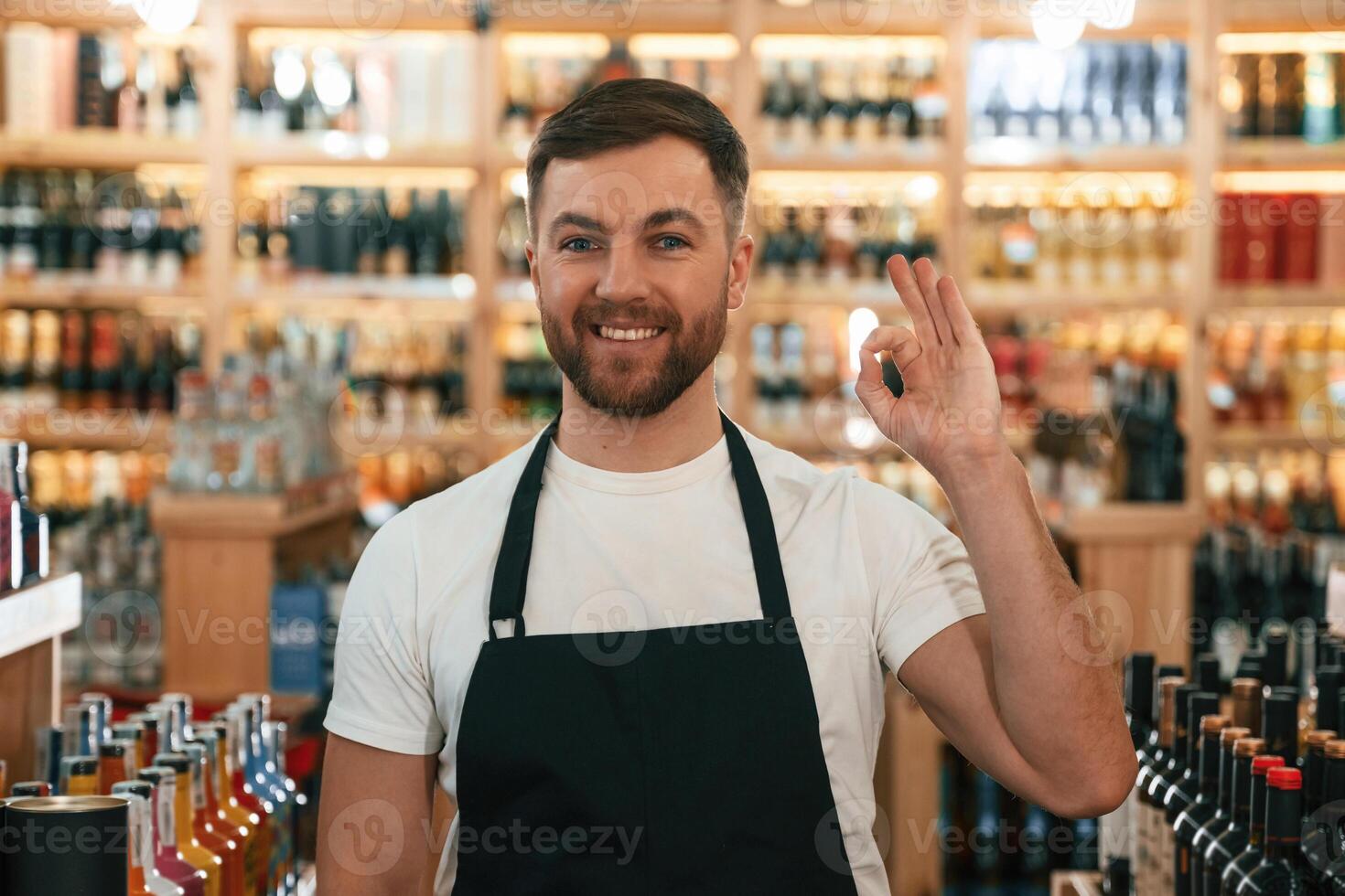Positive, man. Wine shop ,owner, in, white shirt and black apron photo