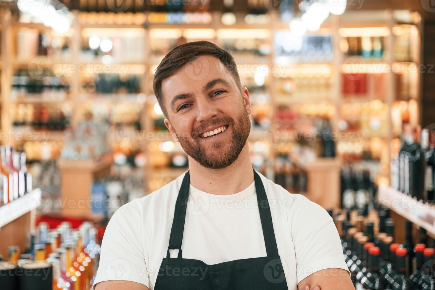 Positive, man. Wine shop owner in white shirt and black apron photo
