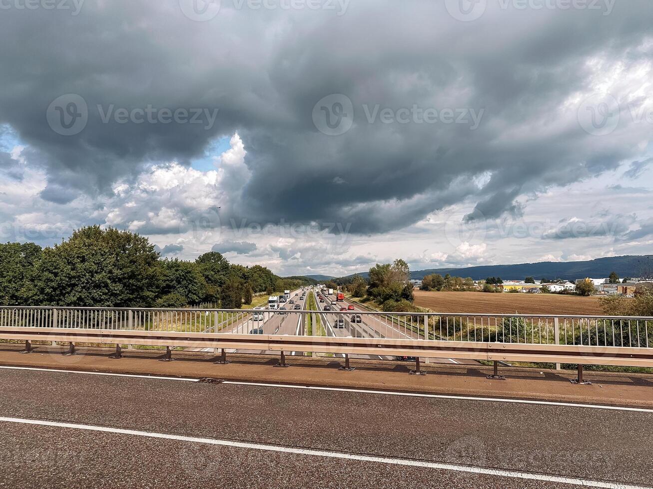 Highway with a bridge over it and a cloudy sky photo