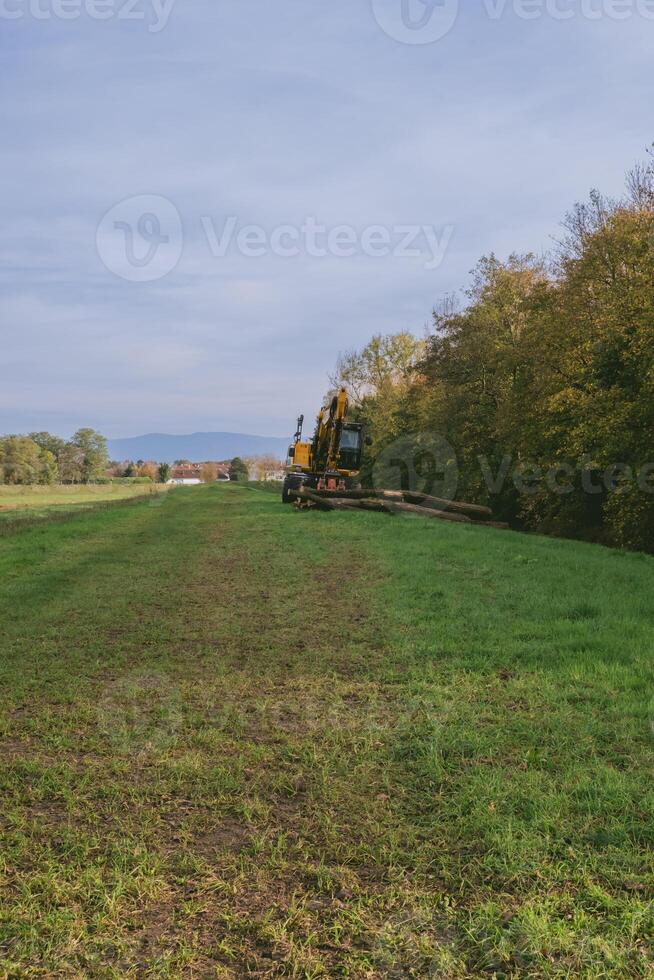 Tractor is in the middle of a field with a cloudy sky in the background photo