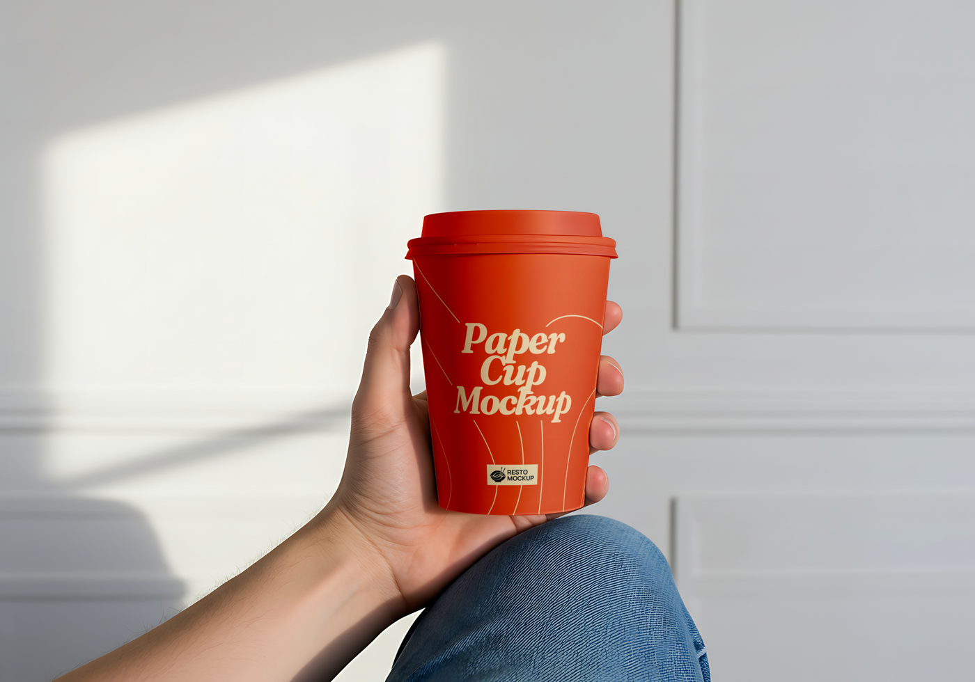 A hand holds a red paper cup mockup psd