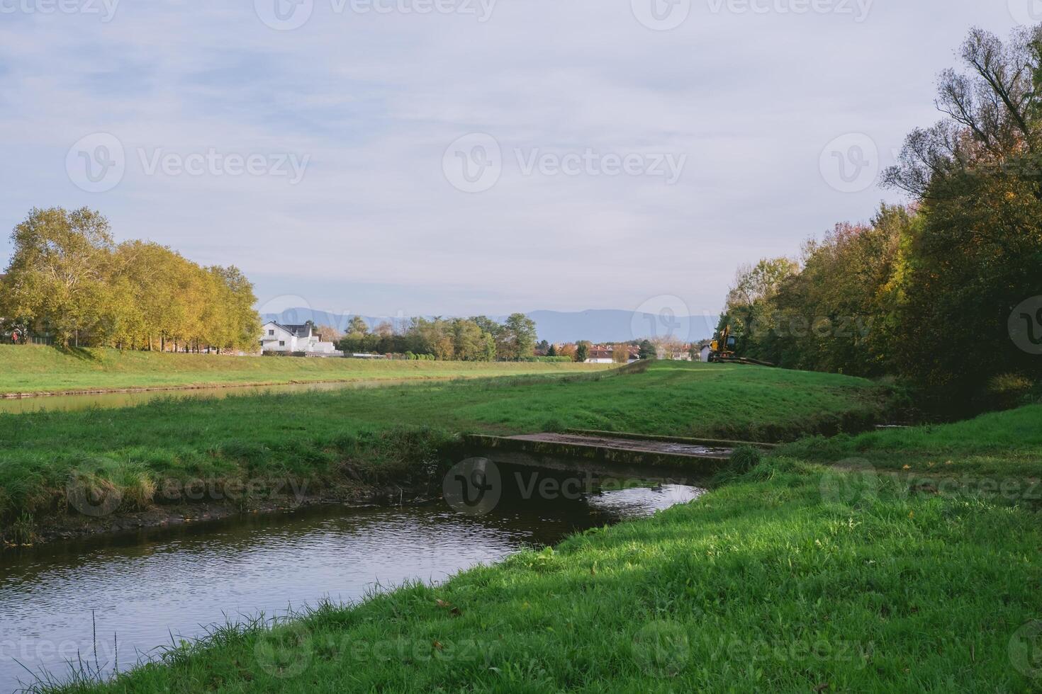 Grassy field with a small stream running through it photo