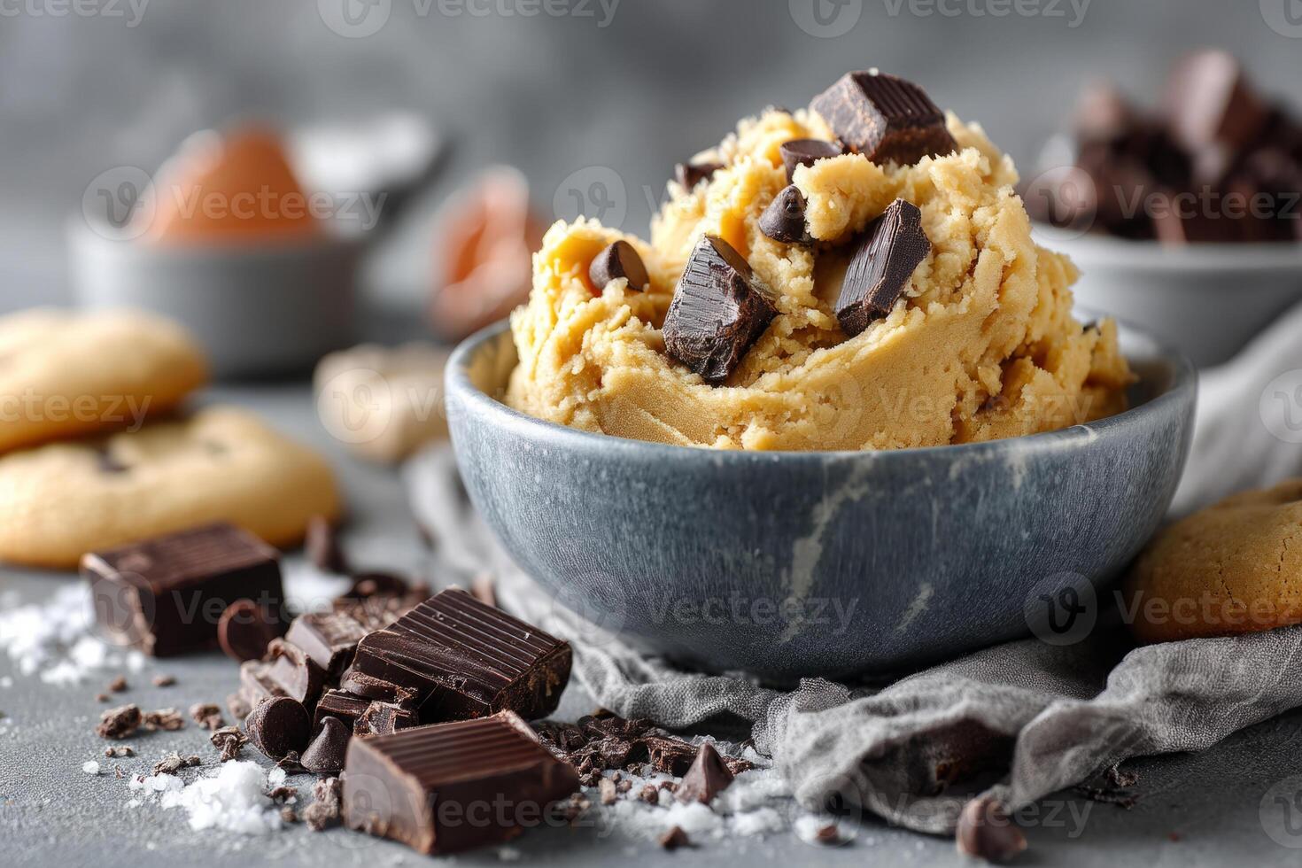 Bowl filled with raw cookie dough topped with dark chocolate chunks photo