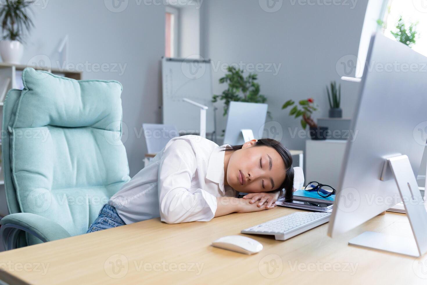 Woman office worker tired Asian sleeps on the desk, overtired sleeps in the day. photo