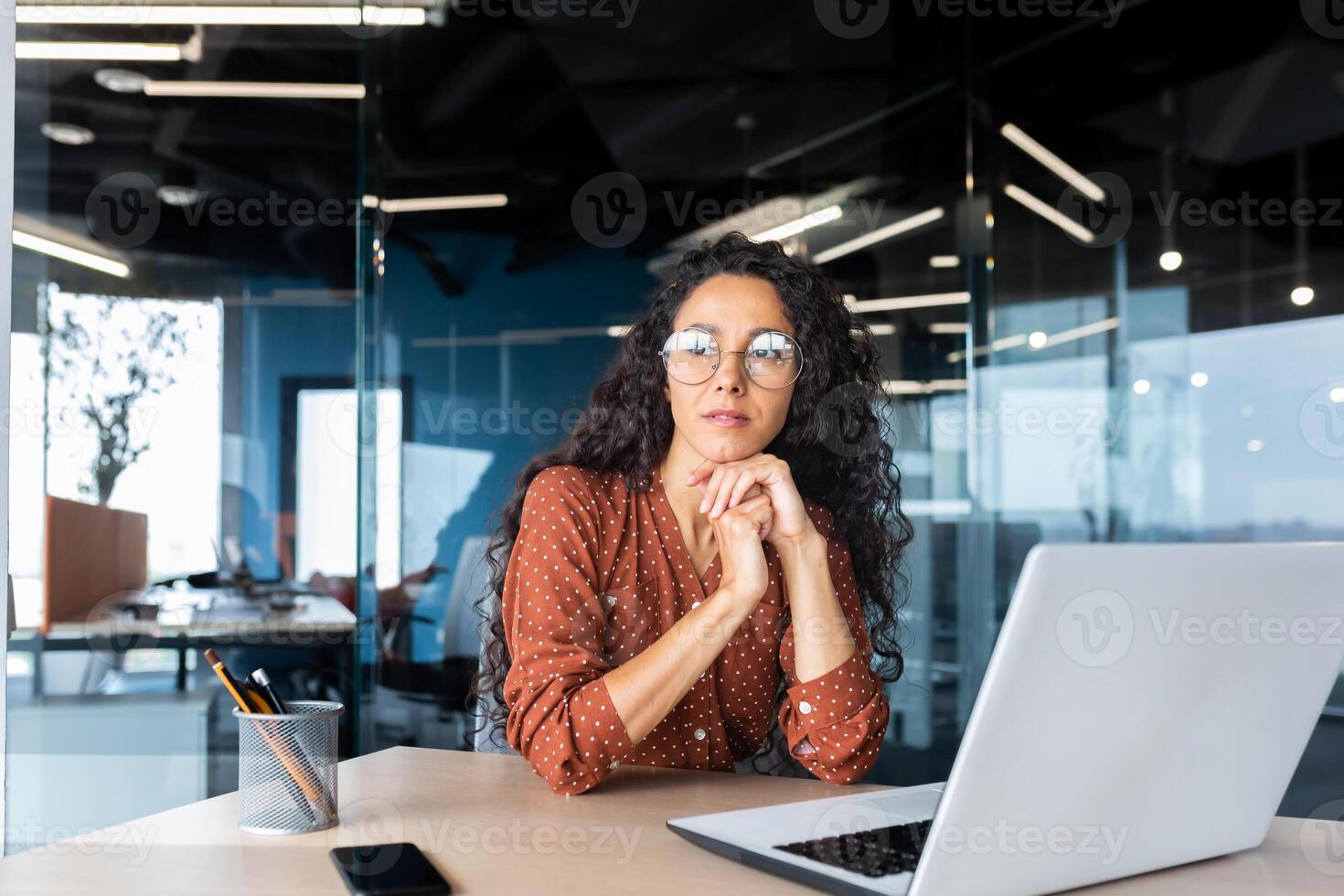 Boring work, hispanic woman working inside office, business woman working at desk using laptop at work. photo