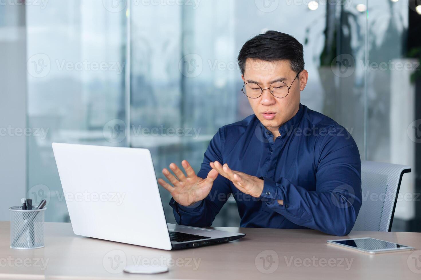 Man panic attack at work, office worker worried breathing hard, asian man depressed and sad thinking, businessman at work using laptop. photo
