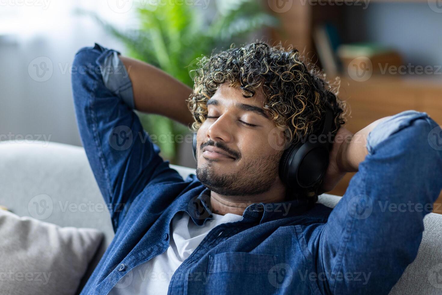 Young man relaxing with headphones, enjoying music on the couch photo