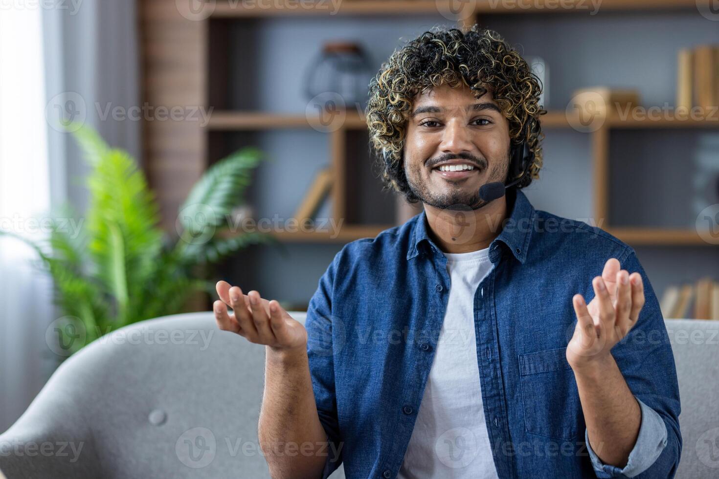 Smiling man hosting a virtual meeting with headset in modern home office photo