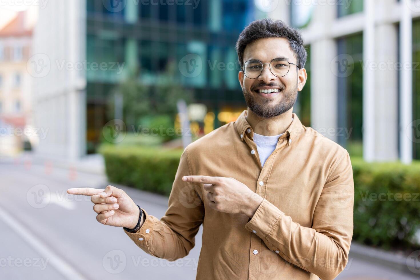 Smiling man pointing in opposite directions outside modern office buildings photo