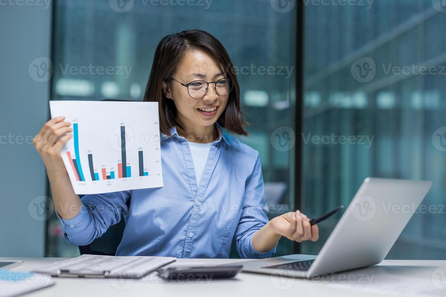 Asian businesswoman presenting data with a bar graph during a conference, showcasing strategy and analysis in a modern office setting. photo