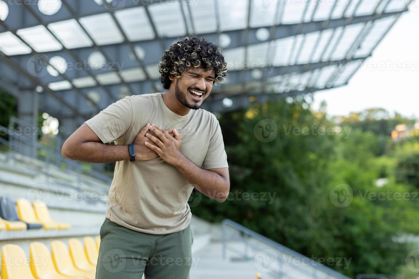Man suffering from chest pain heart attack during active physical training. Athlete holding hands on chest while jogging. photo