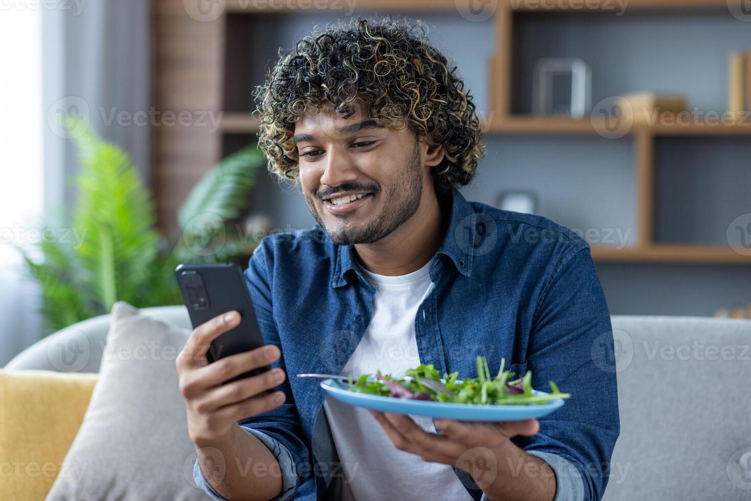 A man uses a phone app to determine the calorie content of his salad. He smiles while analyzing the food photo