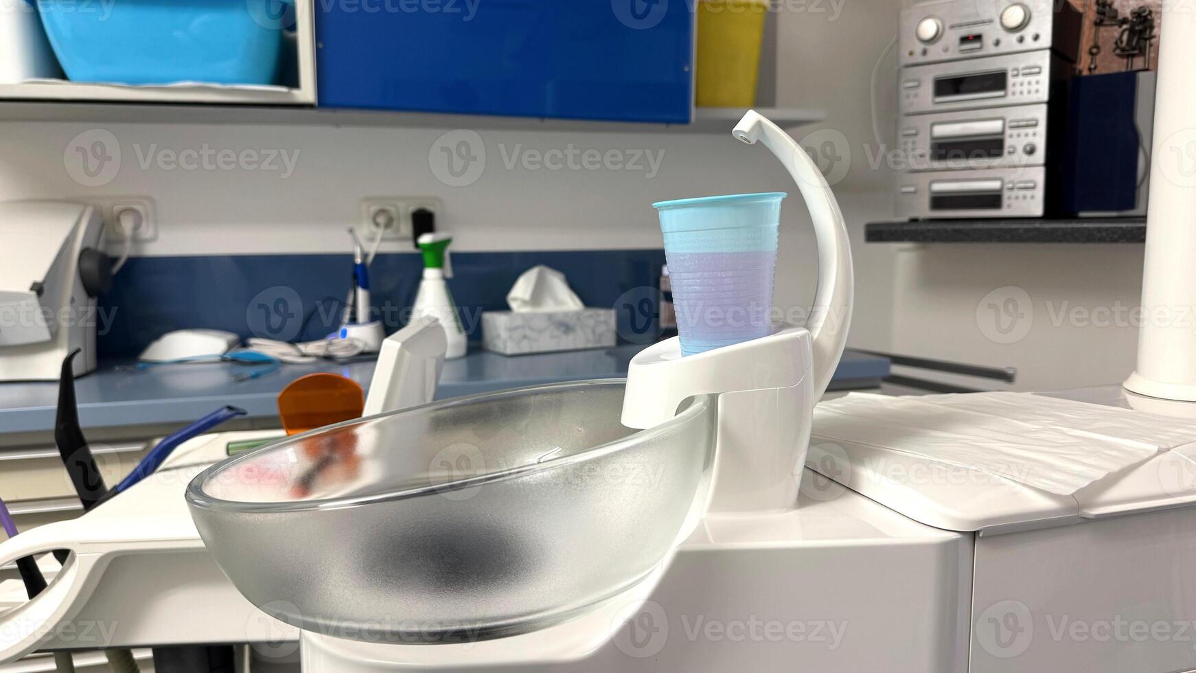 Medical equipment with a transparent bowl and a blue cup on a countertop in a clinical setting showcasing healthcare tools and hygiene concept photo