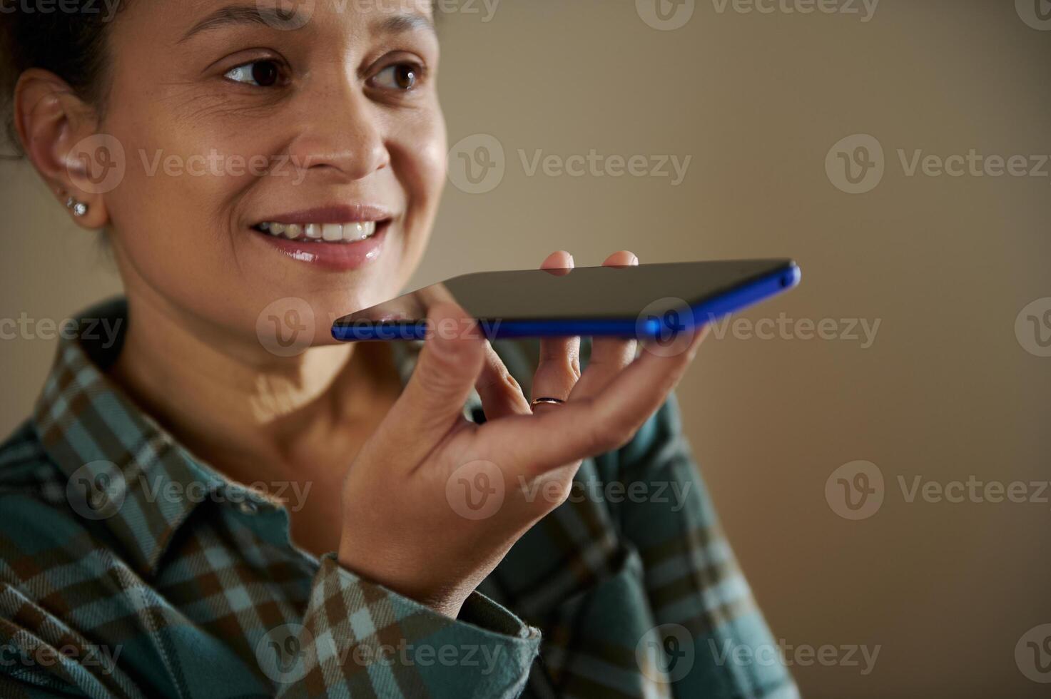 Woman Using Smartphone Voice Assistant at Home for Communication photo
