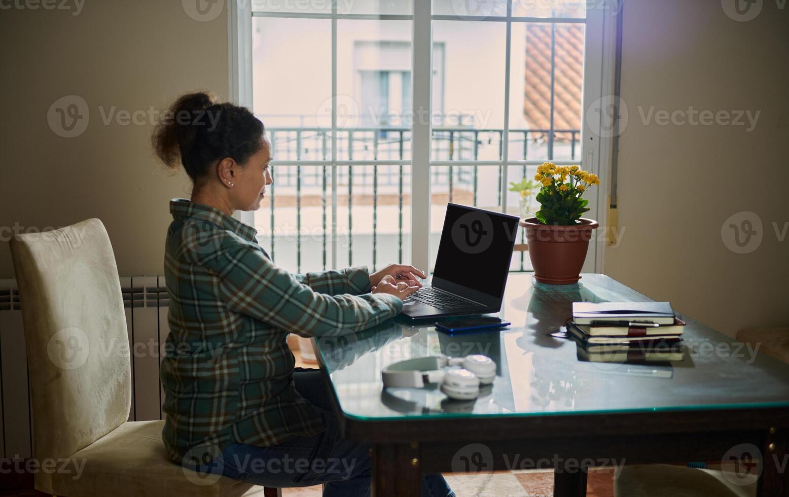 Woman Working Remotely From Home With Laptop Near Window photo
