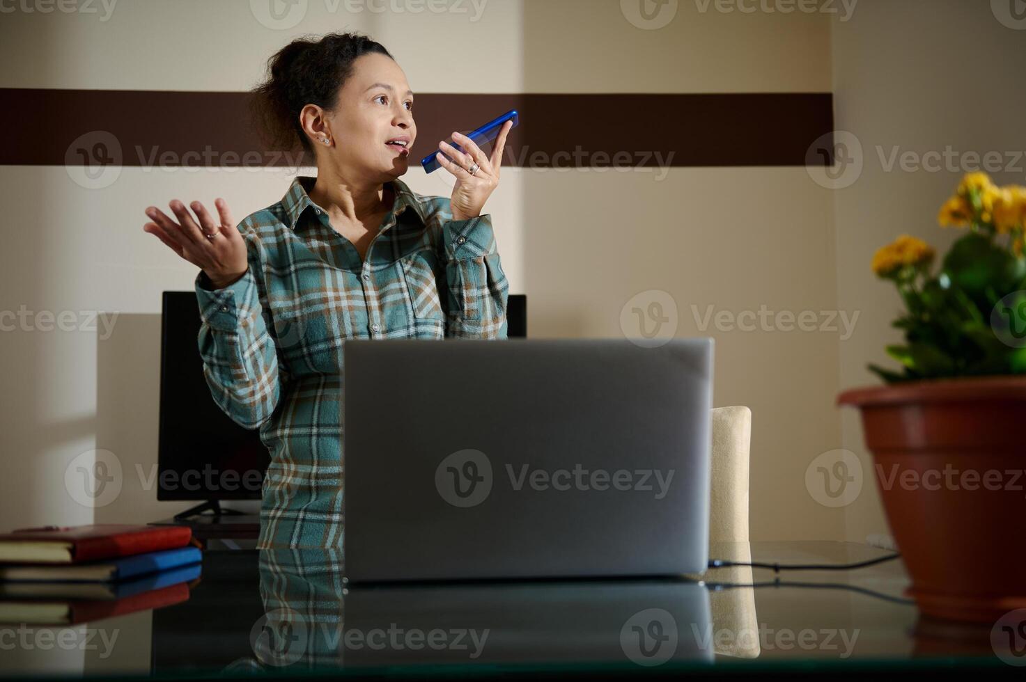 Woman Discussing Work Through Voice Message in a Modern Home Office photo