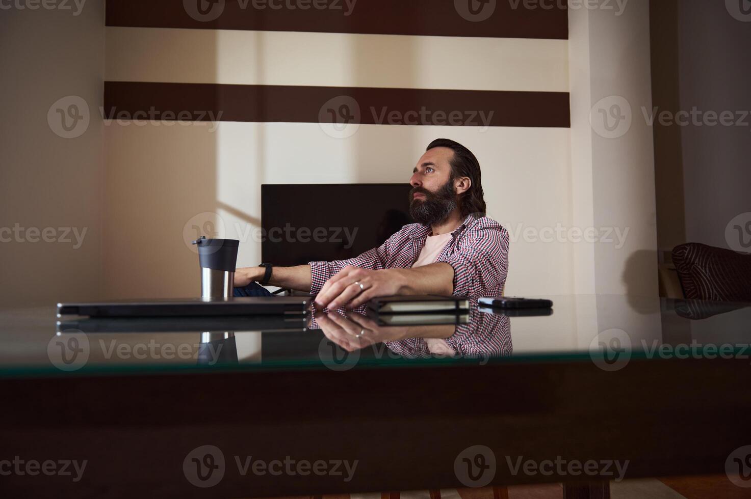 Bearded Man Working at Home Office Desk With Relaxed Expression photo