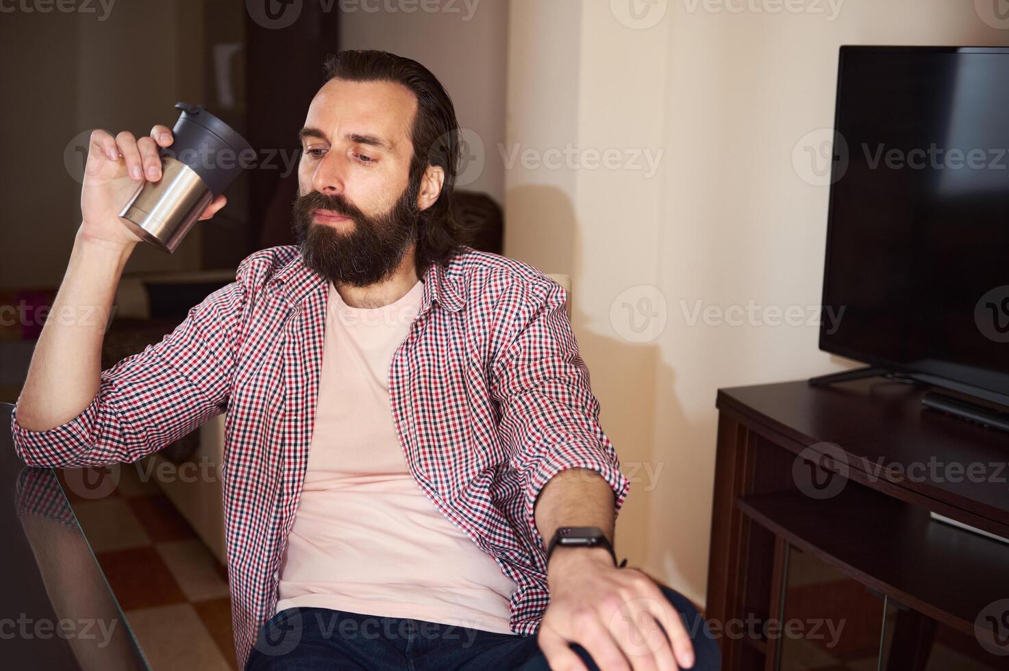 Young Man with Coffee Cup Relaxing in Modern Living Room photo