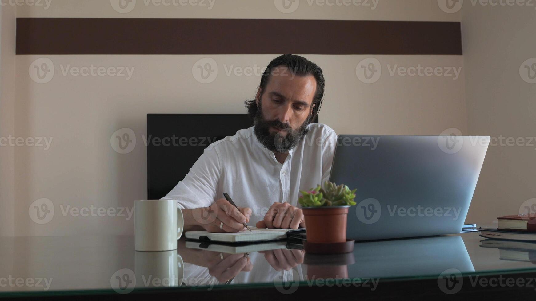 Confident Freelancer Working in Office with Laptop and Notebook photo