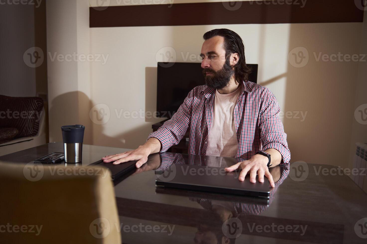 Young Entrepreneur Strategizing at Workspace with Modern Gadgets photo