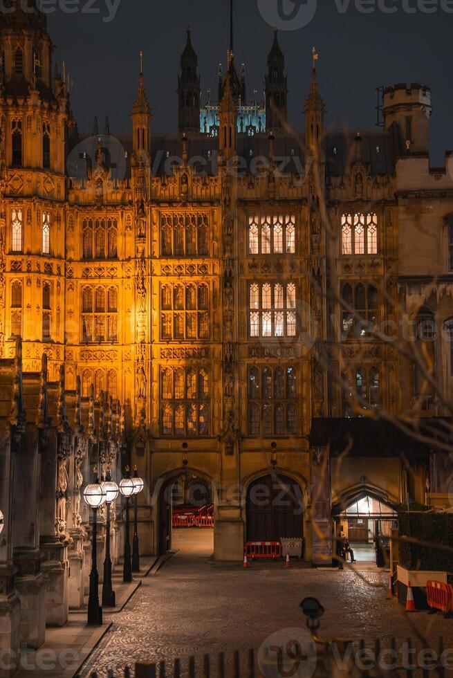 Big Ben and Westminster Bridge stand over the River Thames in London, with historic architecture and urban surroundings visible in the scene. photo